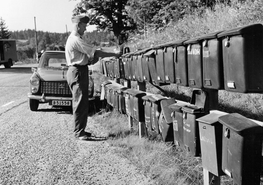 Lantbrevbärare Erik Johansson har kommit fram till den stora brevlådesamlingen vid Singö Handel. Foto: Nils Johansson augusti 1961